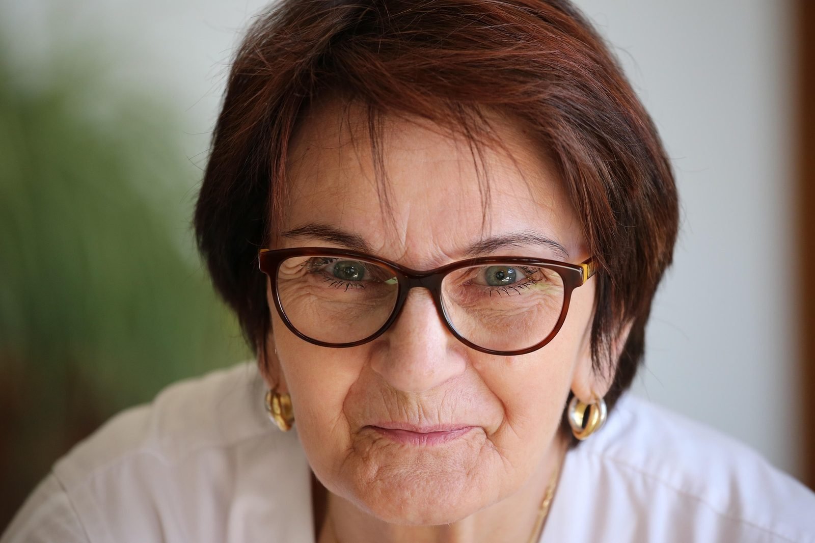 Woman in her 50s with a short reddish bob haircut and glasses