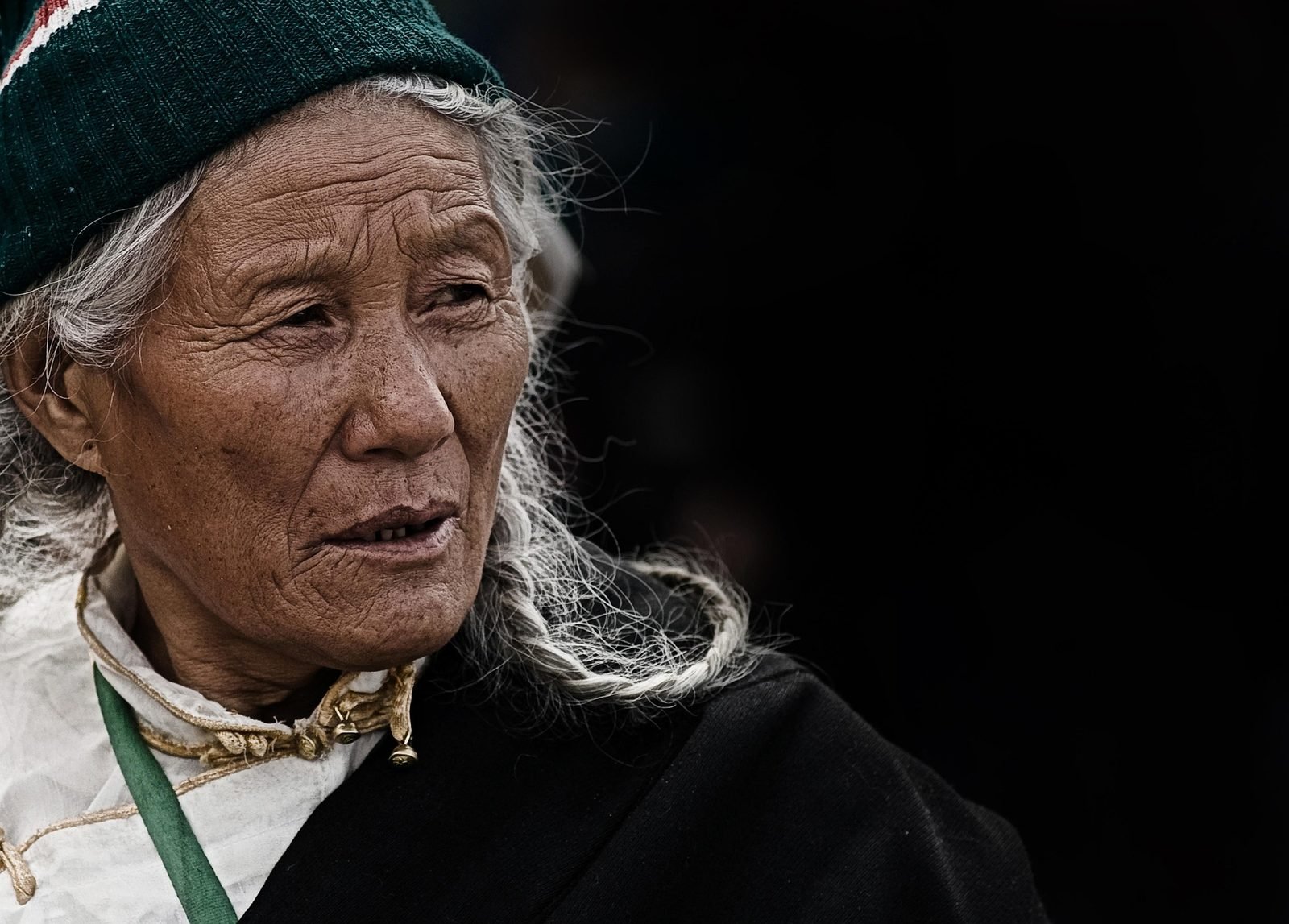 Senior woman with gray hair wearing a green headwrap