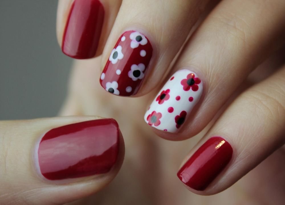 Red nails with a polka-dot accent nail in rubberized 3D nail art